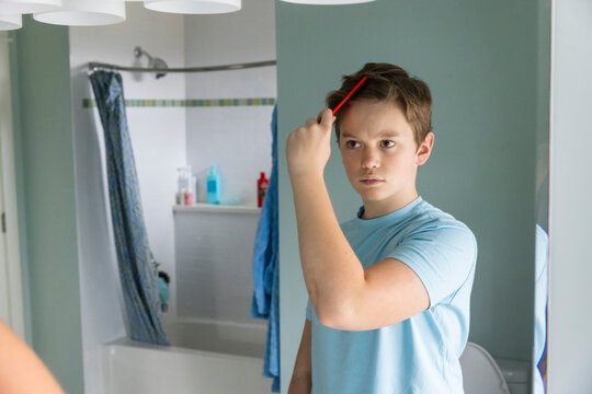 Teen boy Portrait Lifestyle red comb Hair in Mirror bathroom 