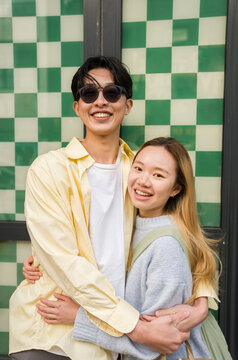 Joyful Couple in Front of a Green Checkered Wall