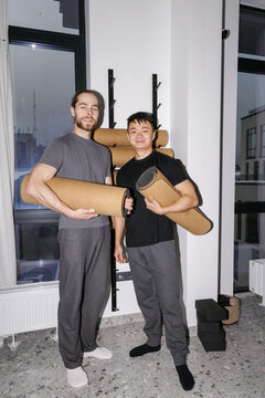 Front of smiling multicultural men in fitness studio at evening time