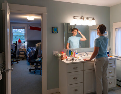 Teen boy Portrait  comb Hair in Mirror bathroom 