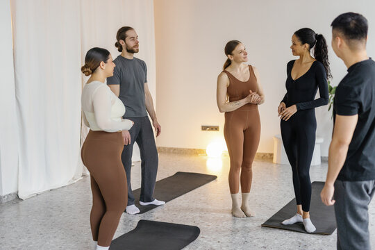 People and female trainer looking at smiling young black woman