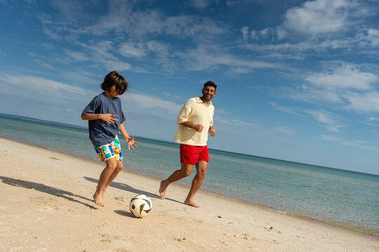 Family playing football together on the beach