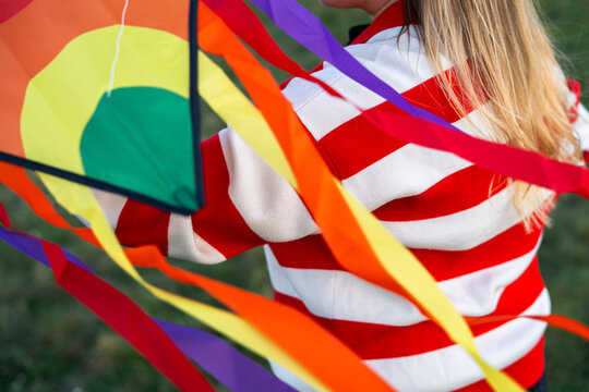 Woman flying a rainbow coloured kite 