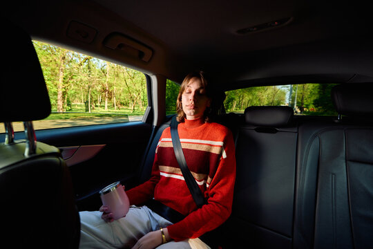 Relaxed woman enjoys the ride in the backseat of a car