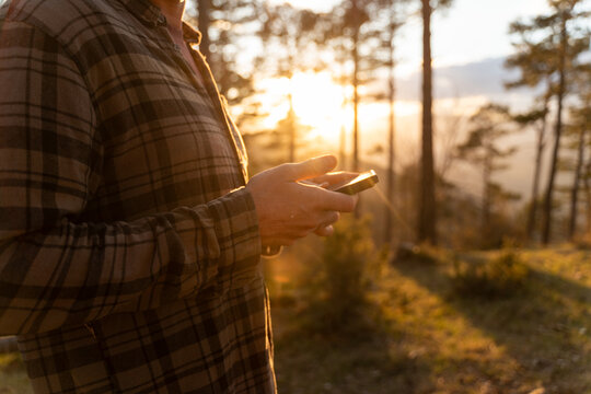 Man Using Smartphone  in Forest  Sunset