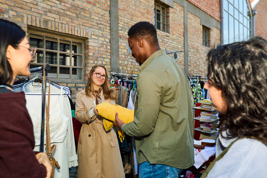 Man Buying a Blanket on a Second Hand Market