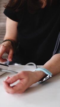 Girl Uses A Digital Blood Pressure Monitor For A Health Check Up, Vertical Video