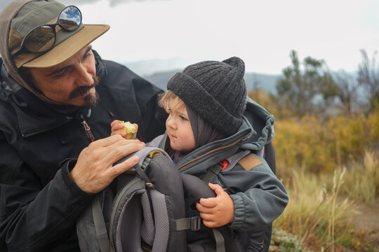 Father Shares Snack With Child During Hike in Nature
