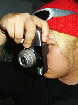Young man using film camera with direct flash portrait
