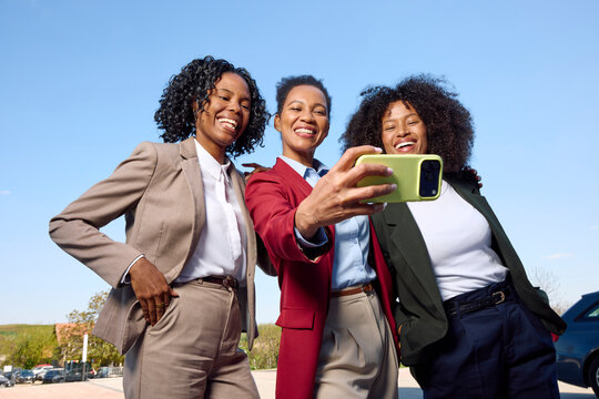 Three Stylish Women Take a Selfie Outdoors 