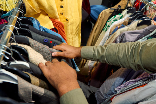 Hands Examining Tweed Jacket at Flea Market