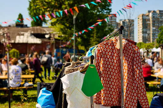 Market Day in the Park With Clothes for Sale and People Enjoying Sun