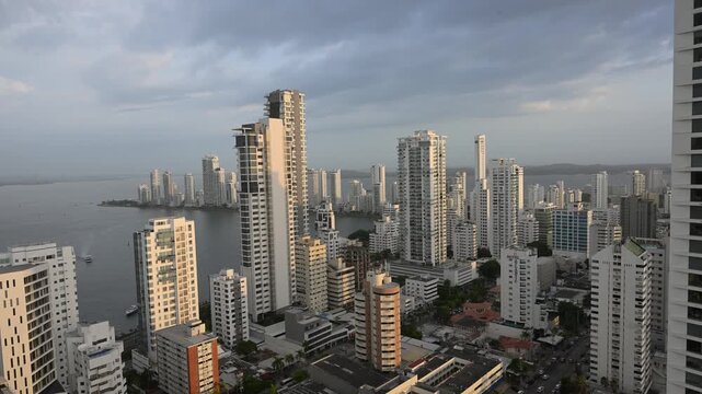 Aerial view of the bocagrande neighborhood in cartagena, colombia, featuring modern skyscrapers and the caribbean sea coastline during a beautiful cloudy sunset