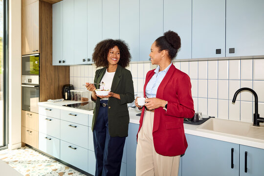 Businesswomen Share Food and Drinks in a Bright Kitchen