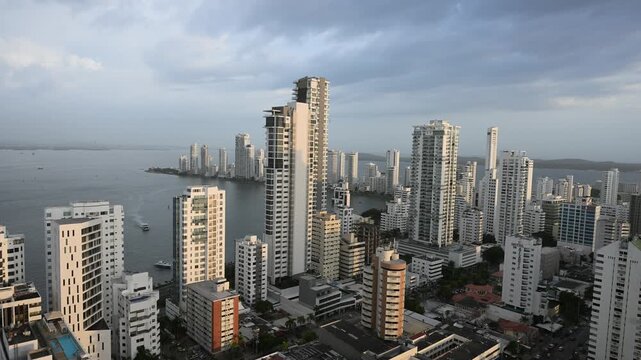 Golden hour light illuminating the modern skyline of cartagena, colombia, with tall skyscrapers and high-rise buildings overlooking the caribbean sea on a cloudy day