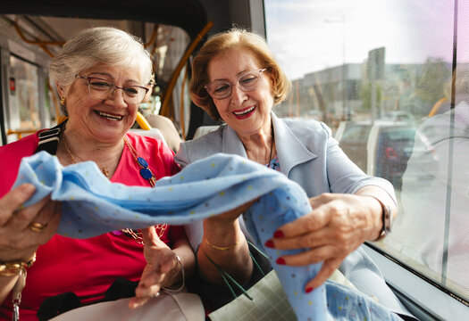 Senior women friends sharing happy shopping moment