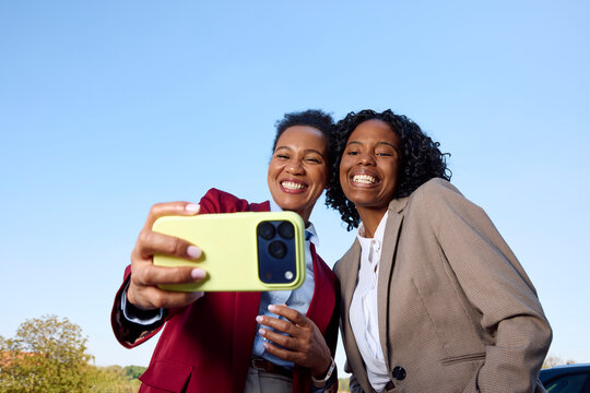 Women Have Fun Taking Selfies While in Suits