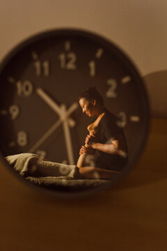 Massage Session is Seen Through a Clock on a Table