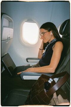 Businesswoman working on a laptop on an airplane during a flight