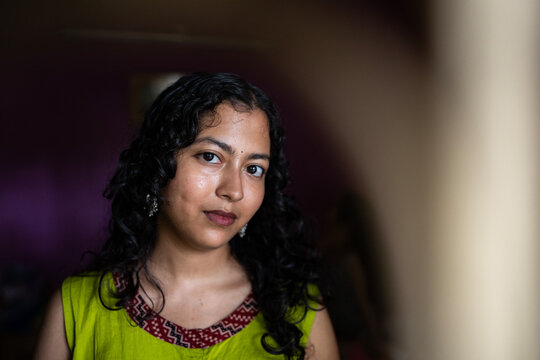 Young Indian woman close up portait at indoors behind the window 