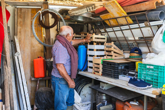 Senior Farmer Organizing Tools in Garden Shed