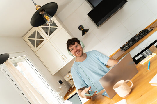 Man Works From Home in Kitchen on Laptop Headphones