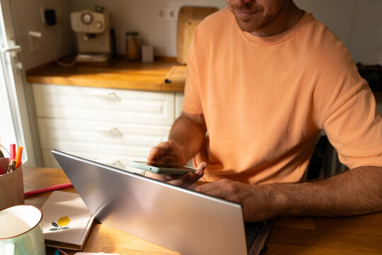 Man Working on Laptop Phone in  Kitchen