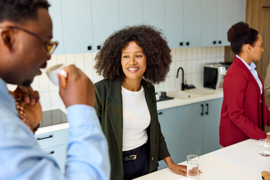 Colleagues having a coffee break in a kitchen setting