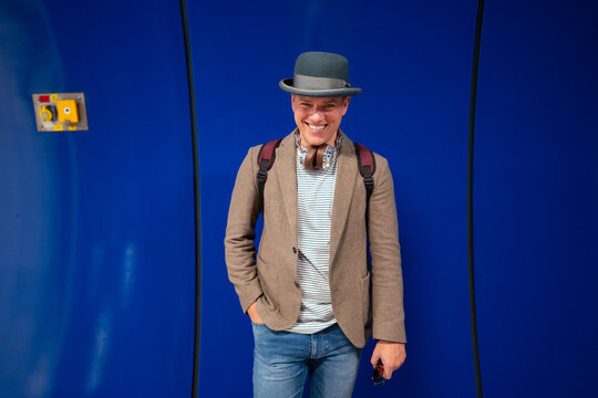 Man standing against blue wall in city