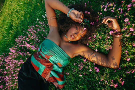 Young  Black  woman laying on grass smiling 