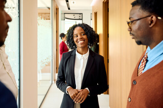 Businesspeople engage in conversation in the hallway