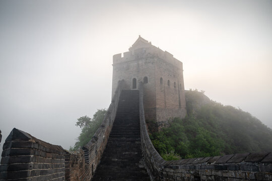 Ancient watchtower emerging from dense morning mist