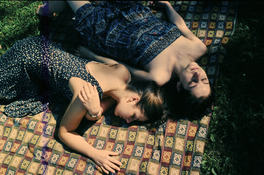 Friends resting on a blanket in the park