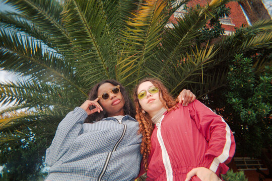 GenZ girl friends posing in the street. Direct flash. UGC. Film