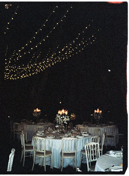 Reception tables beneath string lights at night