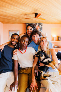 Diverse group of friends and dog making funny faces at home