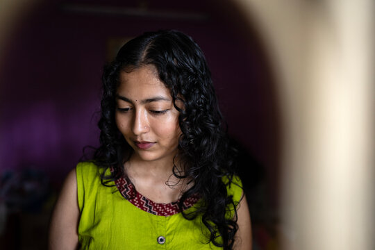 Young Indian woman close up portait at indoors behind the window 