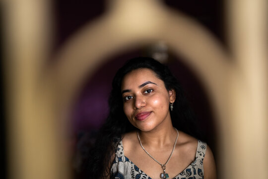 Young Indian woman close up portait at indoors behind the window 