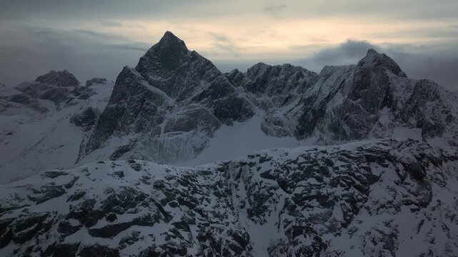 Aerial view of jagged snow mountain peak at dusk