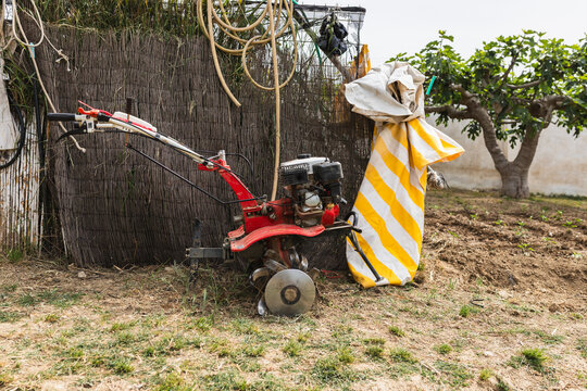 Red Motorized Power Tiller Parked in Rural Farm