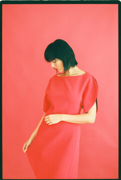 Woman in red dress on pink background