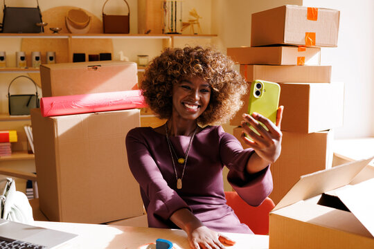 Businesswoman Takes Office Selfie with Smartphone Amid Boxes