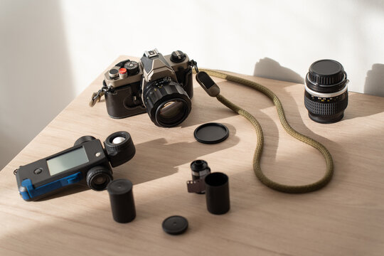 Top view of film camera setup with light meter and film rolls