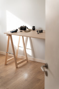 Minimal film photography setup on wooden table with soft sunlight