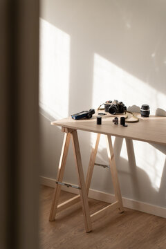 Film camera with accessories on wooden table in soft daylight