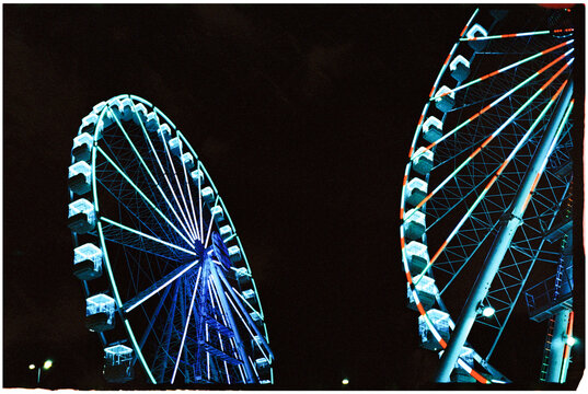 Illuminated Ferris wheels at night
