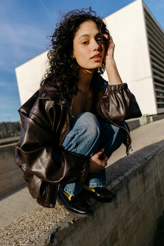 Woman squatting in urban area 