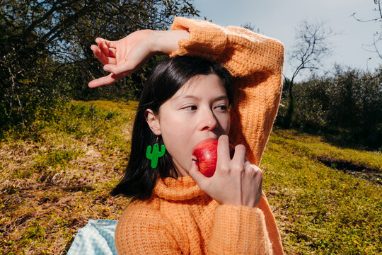 Young Japanese woman eating an apple outdoors