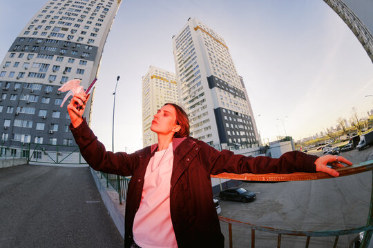 Person Takes Selfie With Modern Buildings in Background at Sunset