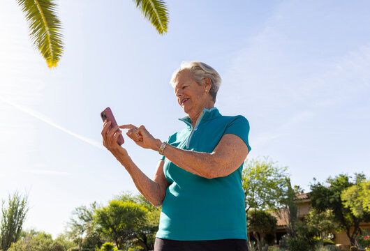 Senior woman texting cell phone outdoors 